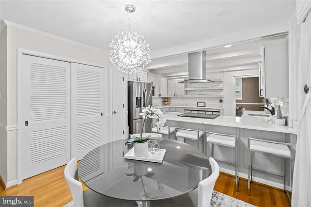 a dining table chair with the view of kitchen chandelier