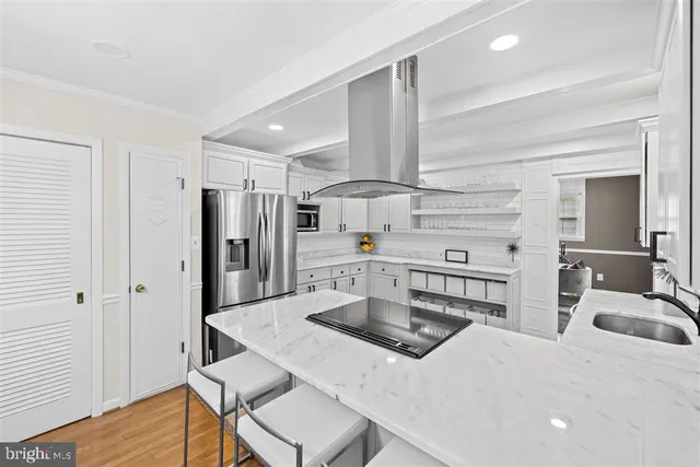 a kitchen with stainless steel appliances kitchen island granite countertop a sink a stove and refrigerator