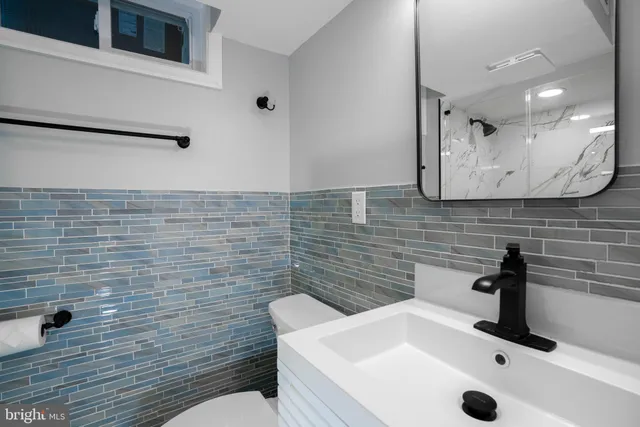 a bathroom with a sink a toilet and mirror