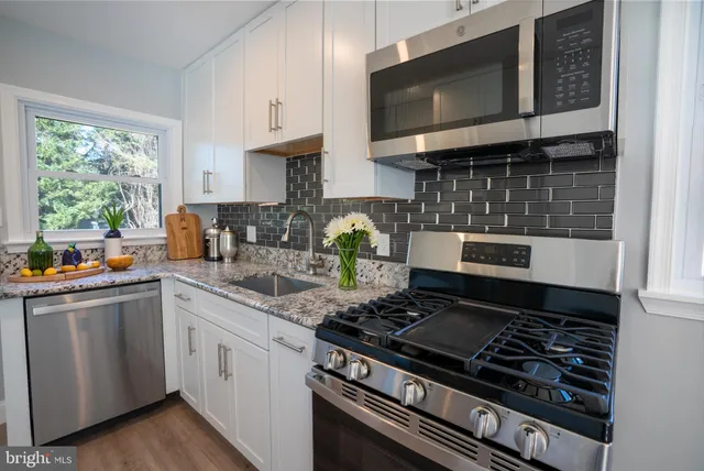 a kitchen with stainless steel appliances granite countertop a stove and a microwave