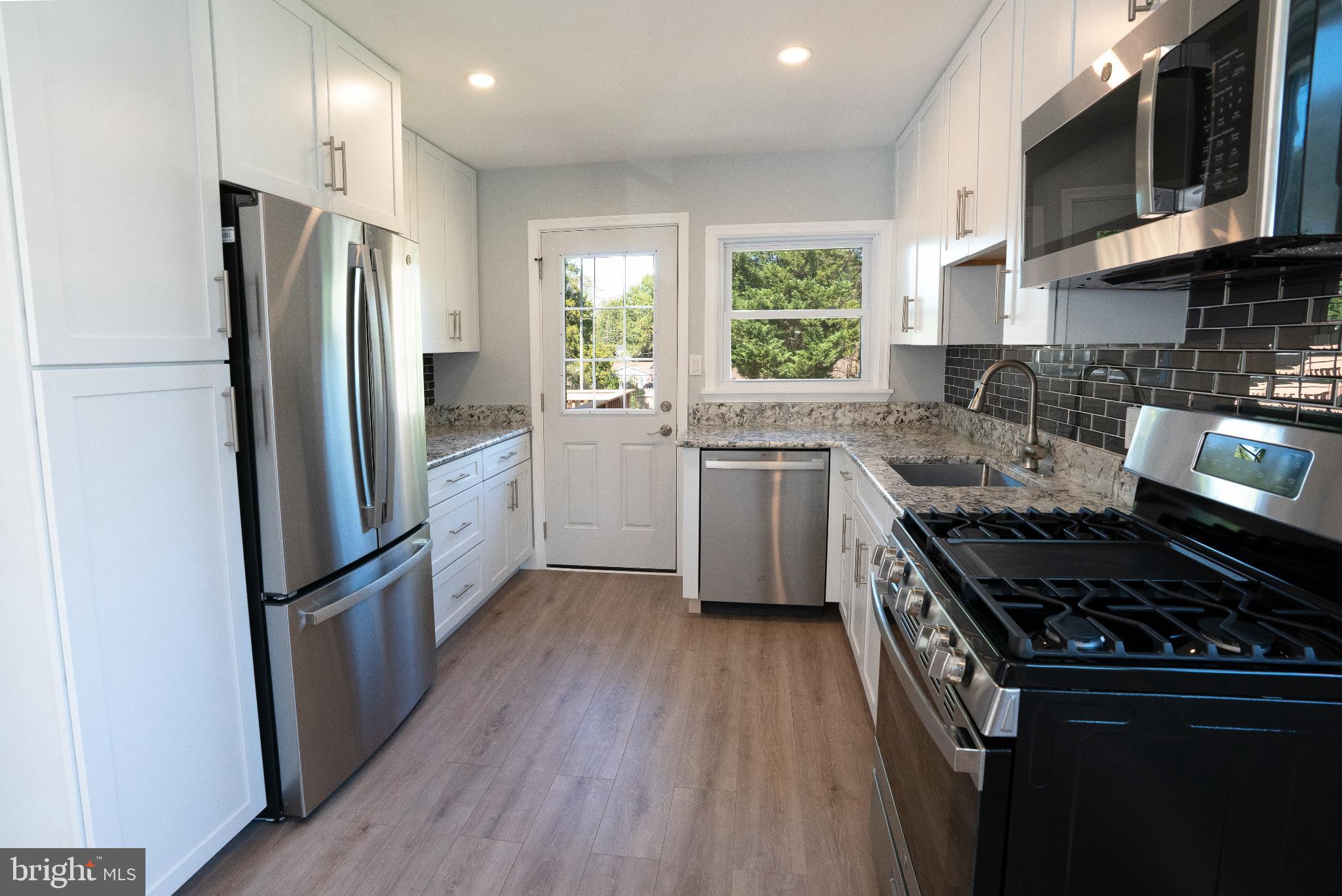 2652 Cory Terrace Silver Spring, MD 20902 - Photo 7 of 33 a kitchen with stainless steel appliances granite countertop a stove a refrigerator and a sink