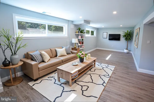 a living room with furniture and a wooden floor