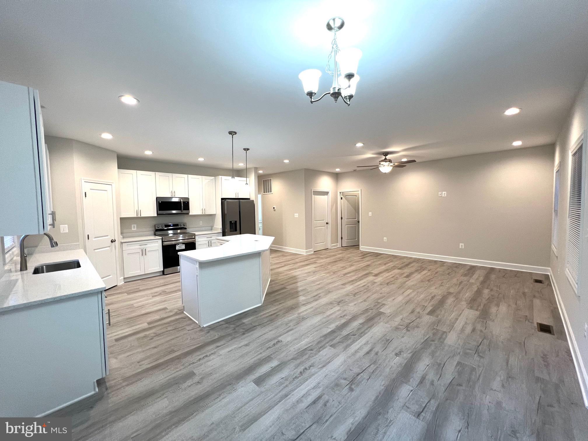 Tbd Lot 31 Tbd Colonial Beach, VA 22443 - Photo 11 of 53 a view of open kitchen with kitchen island stainless steel appliances refrigerator stove microwave and fireplace