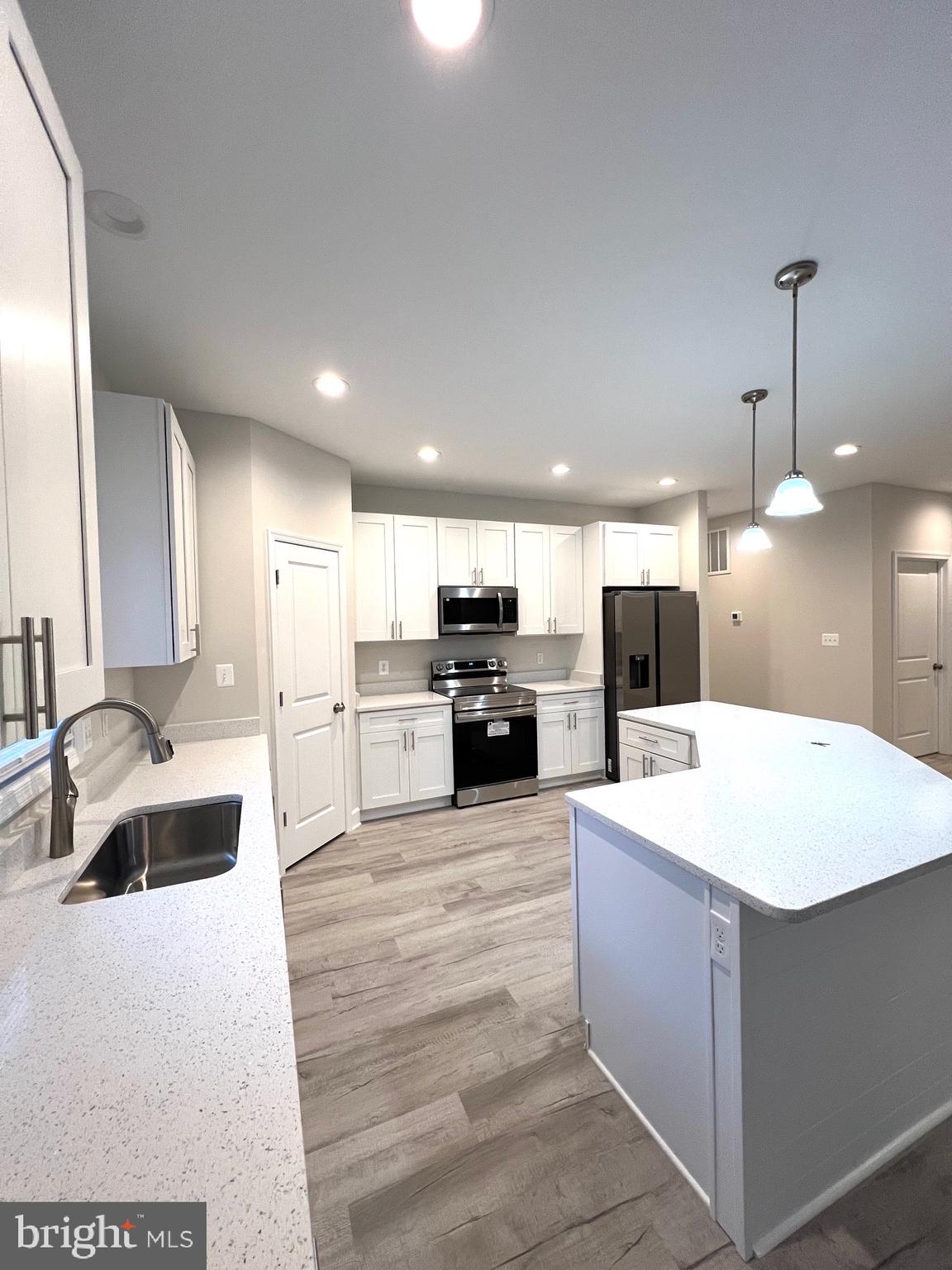 Tbd Lot 31 Tbd Colonial Beach, VA 22443 - Photo 12 of 53 a large white kitchen with a large counter top a sink stainless steel appliances and cabinets