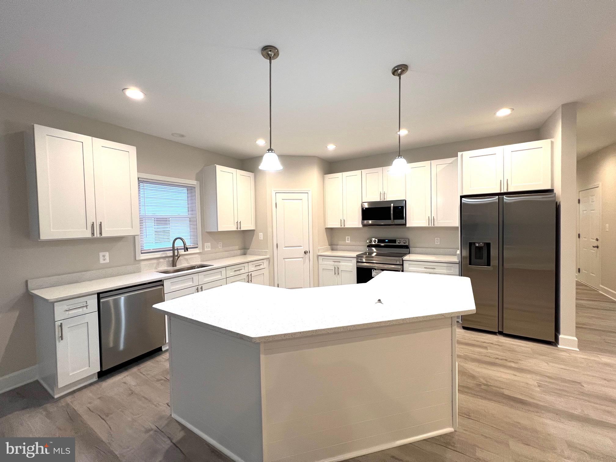 Tbd Lot 31 Tbd Colonial Beach, VA 22443 - Photo 13 of 53 a kitchen with stainless steel appliances kitchen island granite countertop a sink a stove a refrigerator and island with wooden floor