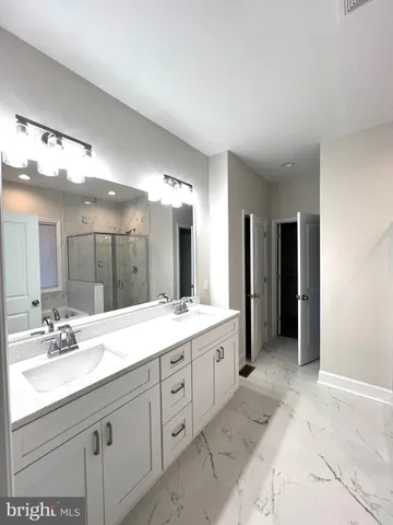 a spacious bathroom with a granite countertop sink mirror and double