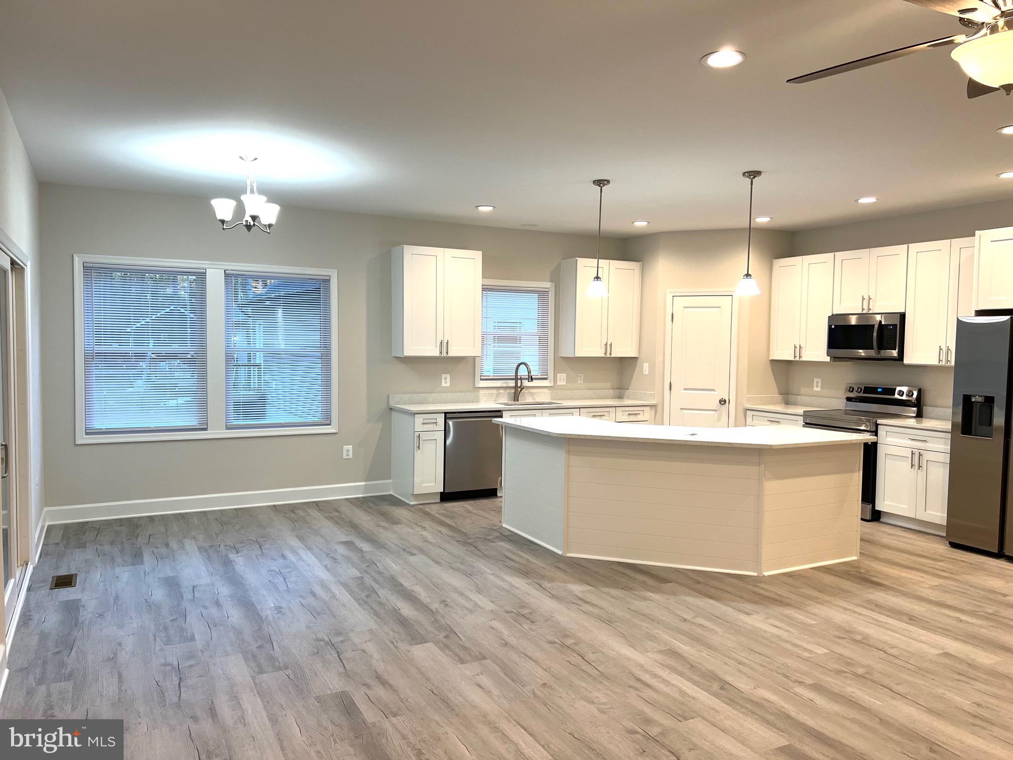 Tbd Lot 31 Tbd Colonial Beach, VA 22443 - Photo 8 of 53 a large kitchen with kitchen island a sink wooden floor and stainless steel appliances