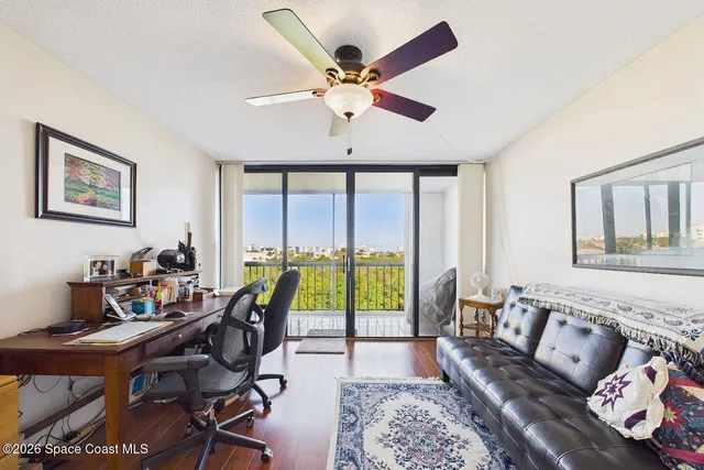 a view of a workspace with furniture and a window