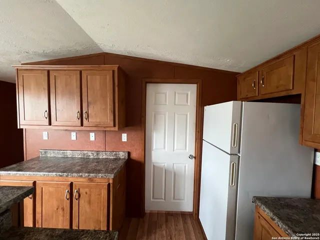 a kitchen with stainless steel appliances granite countertop a refrigerator and a stove