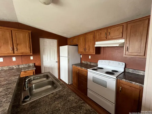 a kitchen with a stove cabinets and a refrigerator