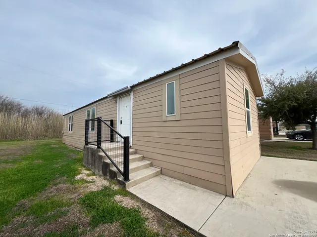 a view of a house with backyard and trees