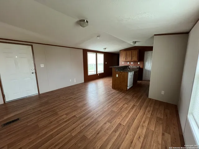 a view of a kitchen with furniture and wooden floor