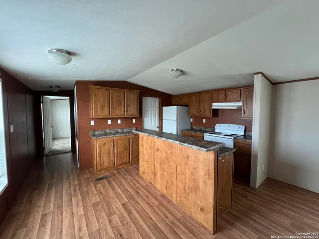 a kitchen with stainless steel appliances granite countertop a stove cabinets and wooden floor