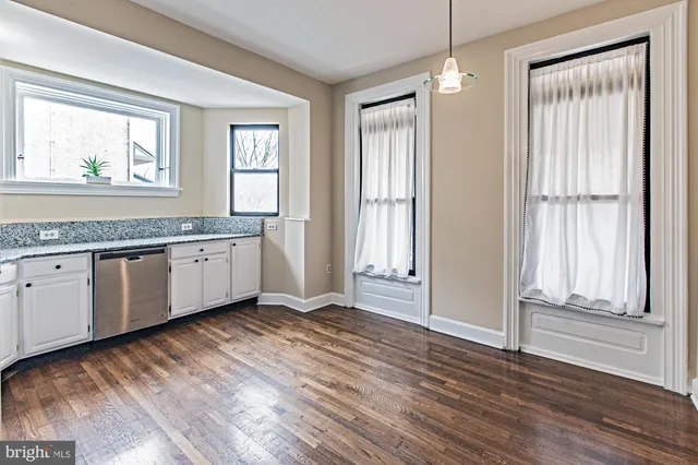 a view of a kitchen with wooden floor and electronic appliances