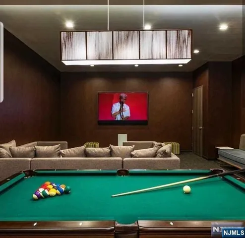 a room with furniture pool table and kitchen view