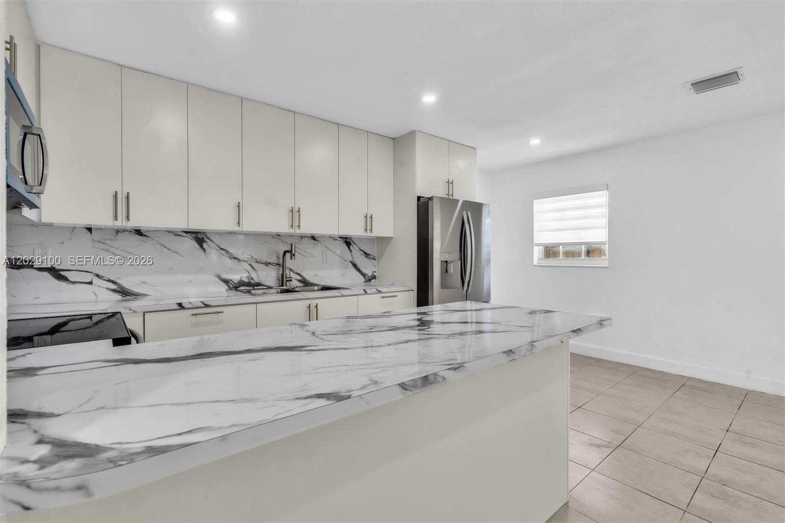11790 Southwest 34th Street Miami, FL 33175 - Photo 11 of 56 a kitchen with stainless steel appliances granite countertop a sink a stove a refrigerator and white cabinets