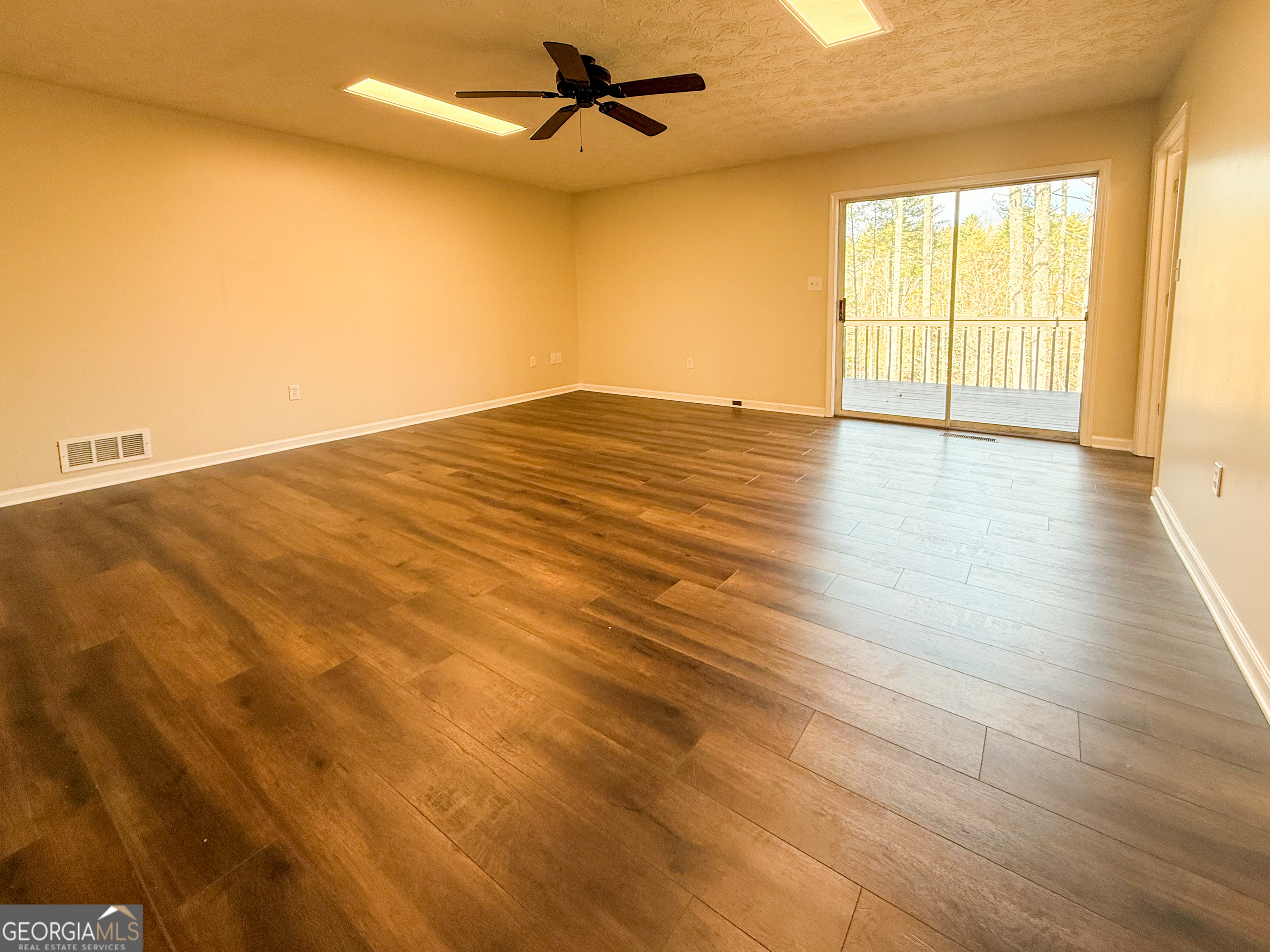 499 Old Deer Path Way Cleveland, GA 30528 - Photo 14 of 26 wooden floor in an empty room with a window