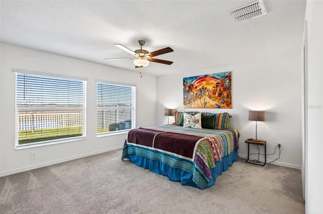 a spacious bedroom with a bed a window and a chandelier