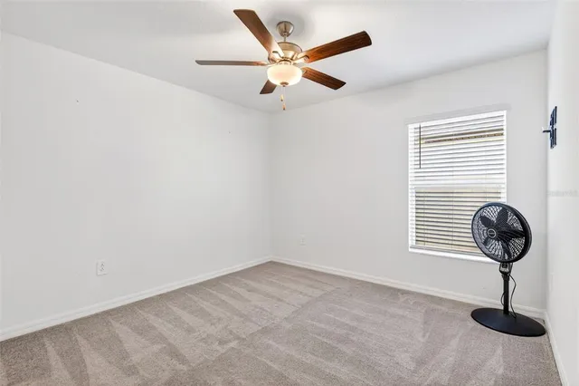 a view of wooden floor and a chandelier fan in a room