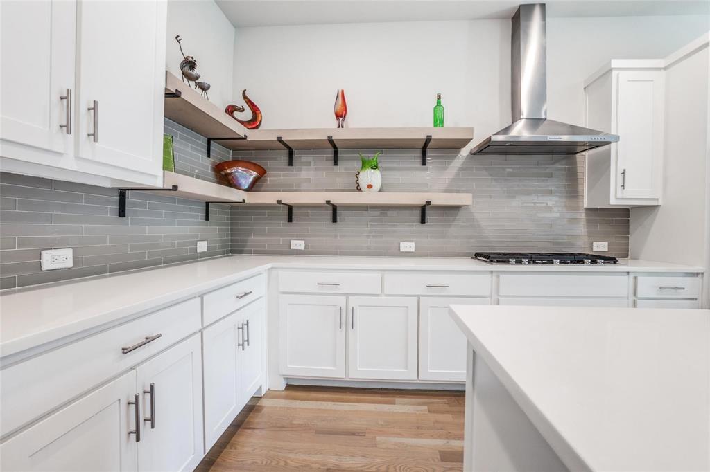 4785 Asher Place Dallas, TX 75204 - Photo 11 of 30 a kitchen with stainless steel appliances granite countertop a sink white cabinets and a wooden floors