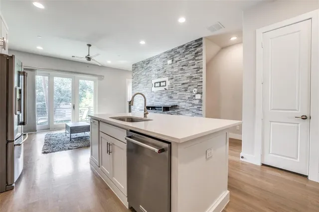 a kitchen with a sink and wooden floor