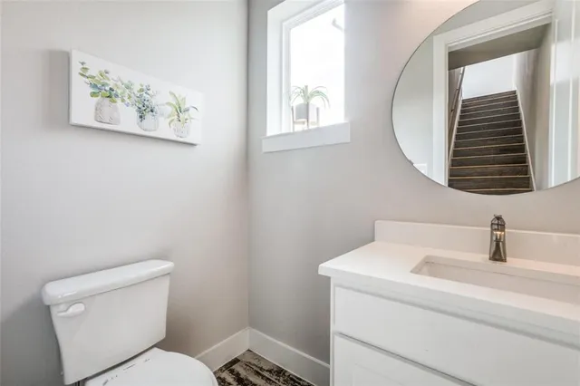a bathroom with a toilet a sink and mirror
