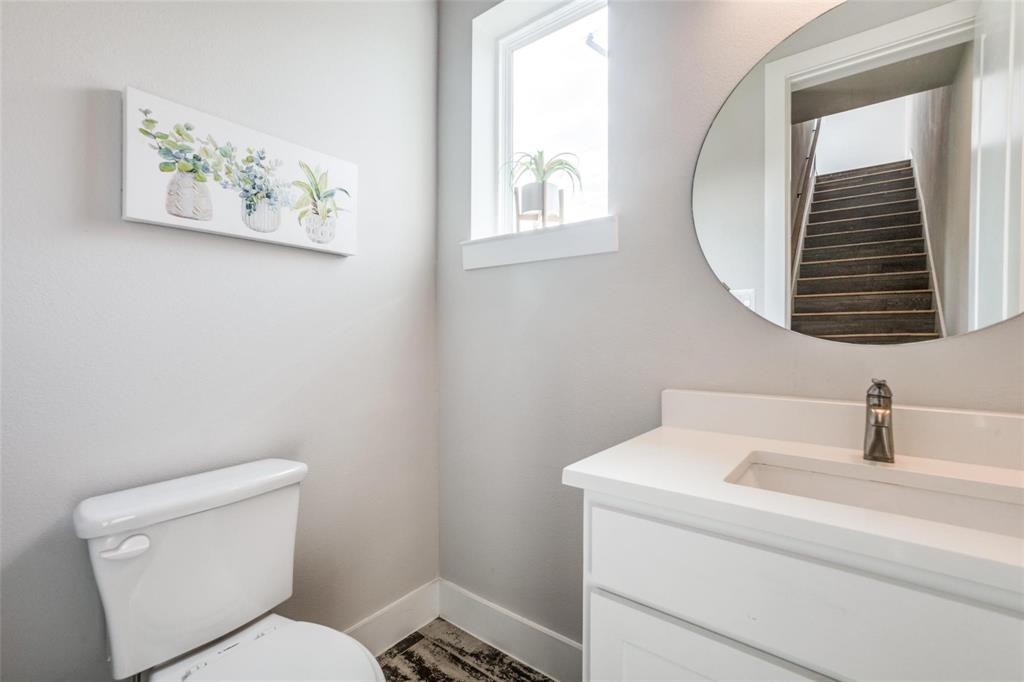 4785 Asher Place Dallas, TX 75204 - Photo 15 of 30 a bathroom with a toilet a sink and mirror