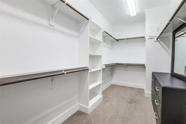 a view of walk in closet with empty racks