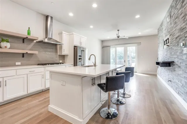 a large kitchen with stainless steel appliances a lot of counter space and a wooden floors