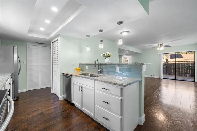 a kitchen with granite countertop white cabinets and white appliances