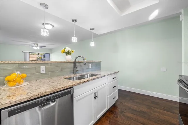 a kitchen with stainless steel appliances granite countertop a stove microwave and sink
