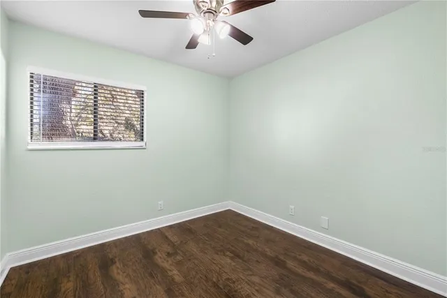 an empty room with wooden floor & closet area