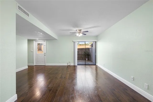 a view of a big room with wooden floor and windows