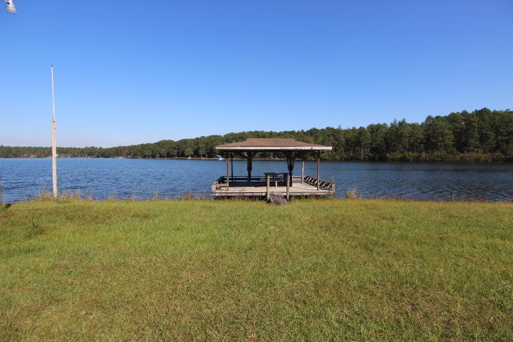10 Spring Lake Road DeFuniak Springs, FL 32433 - Photo 8 of 14 a view of a lake with a table and chairs