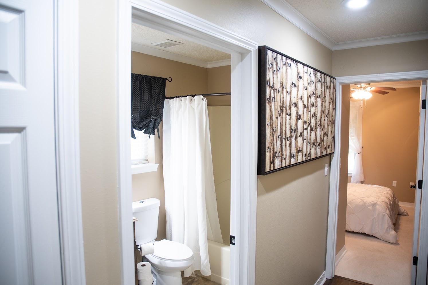 2802 Ping Lane Crestview, FL 32539 - Photo 22 of 30 a bathroom with a toilet and a shower curtain