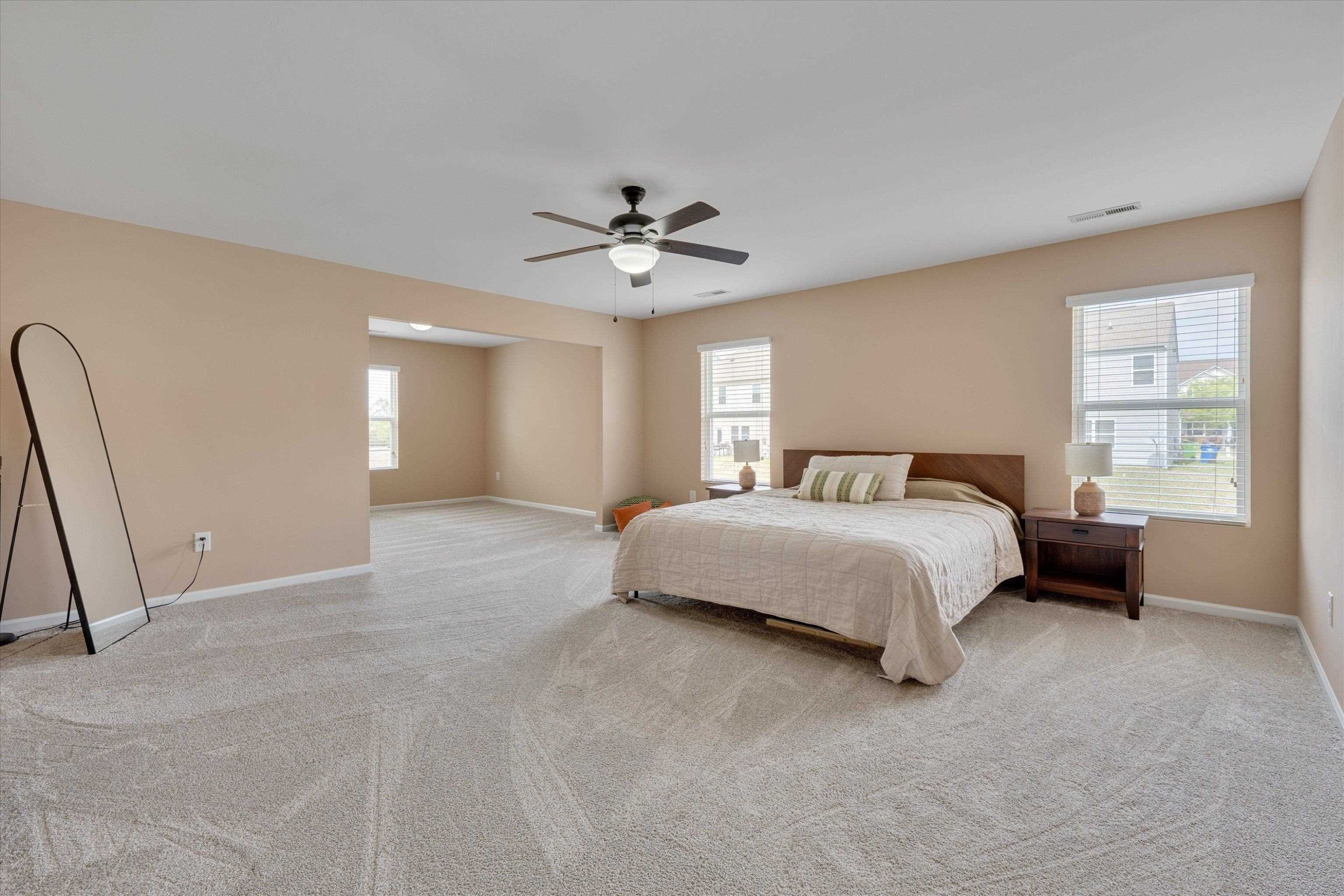 3717 Althorp Drive Raleigh, NC 27616 - Photo 14 of 23 a spacious bedroom with a bed a dresser and a chandelier