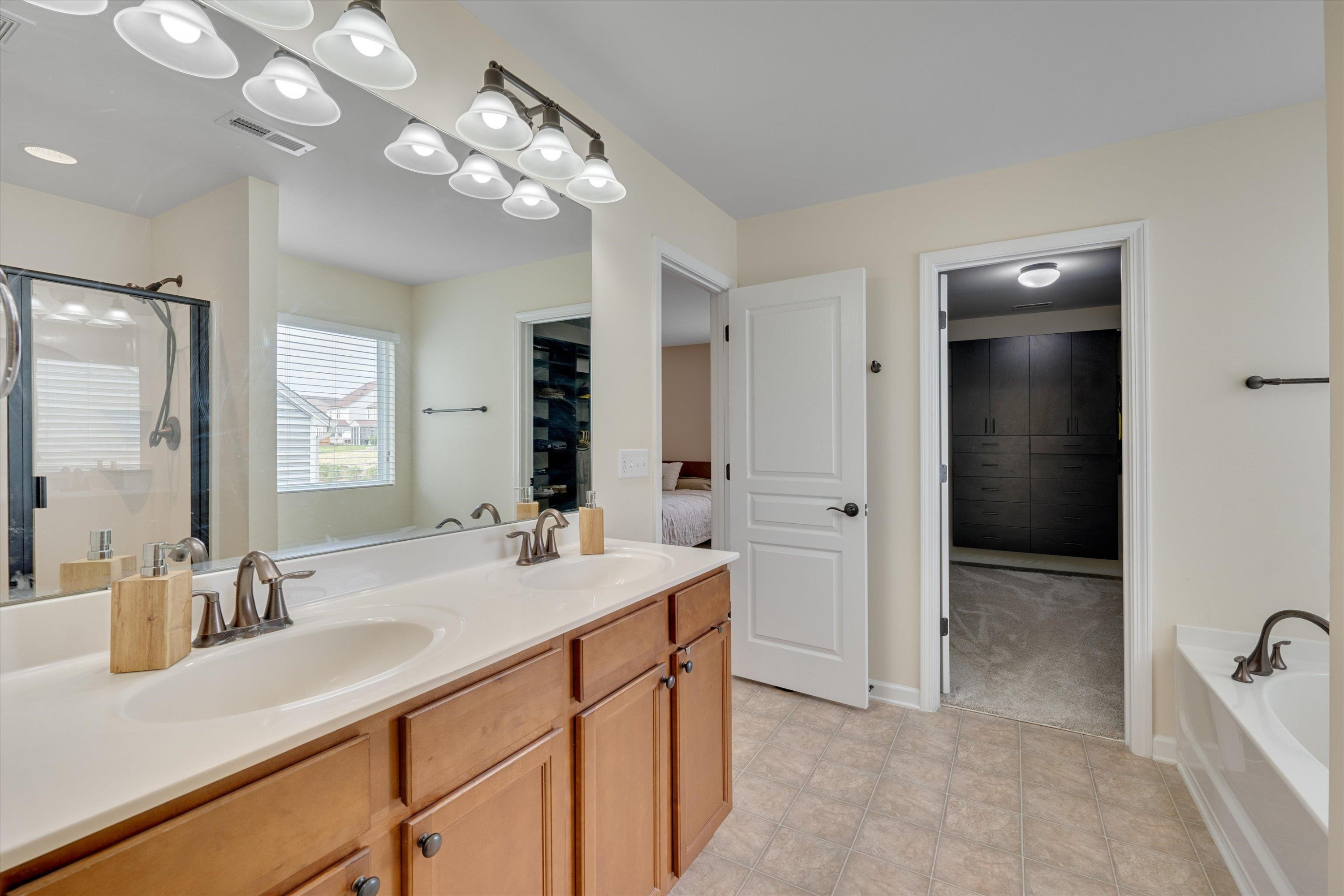 3717 Althorp Drive Raleigh, NC 27616 - Photo 17 of 23 a bathroom with a sink double vanity granite tub shower and a mirror