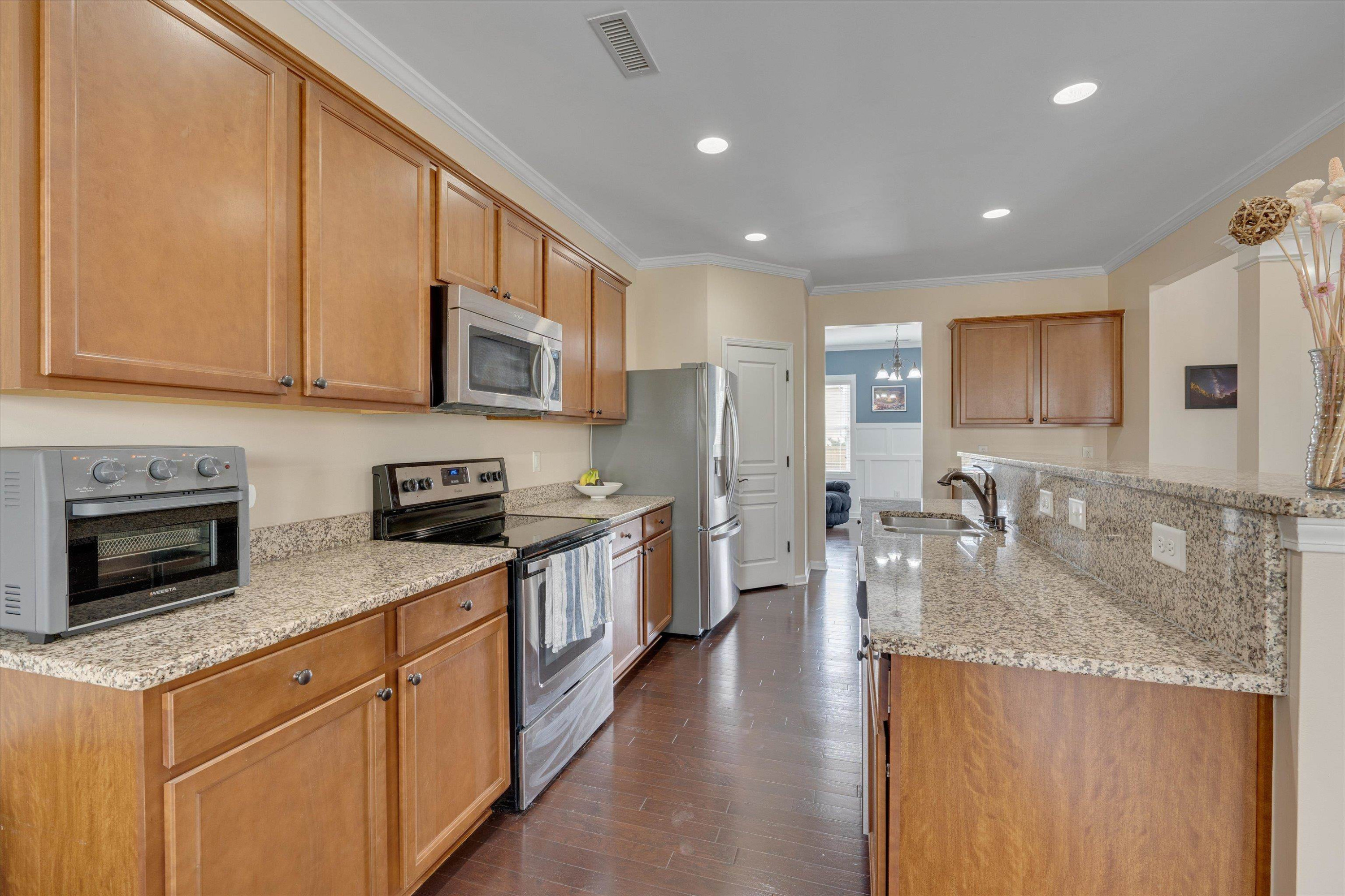 3717 Althorp Drive Raleigh, NC 27616 - Photo 5 of 23 a kitchen with stainless steel appliances granite countertop a stove a sink a refrigerator a microwave oven with white cabinets