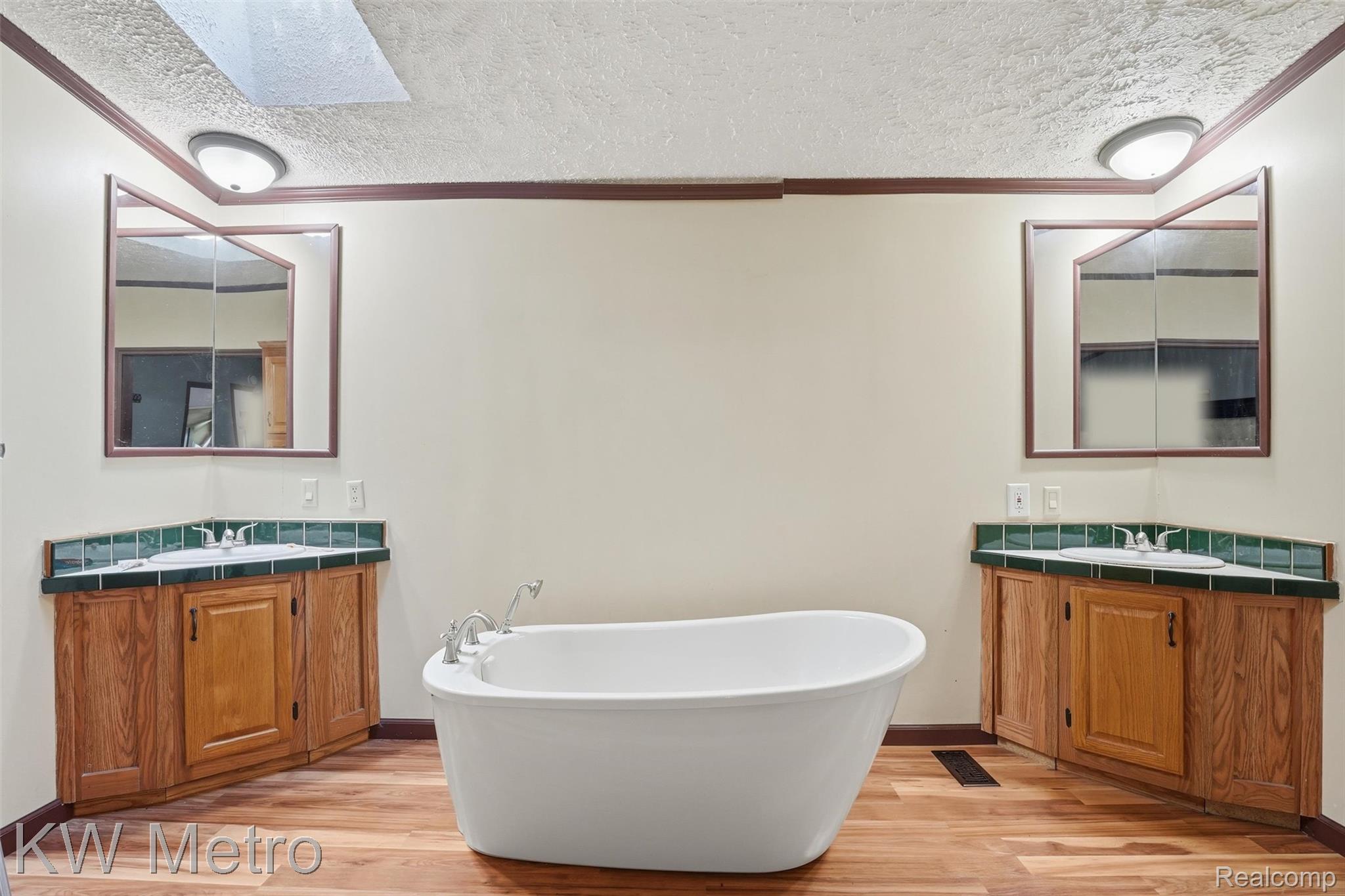 22733 Sumpter Road Belleville, MI 48111 - Photo 13 of 52 Freestanding soaking tub with dual corner vanities featuring wood cabinetry and green tile backsplashes