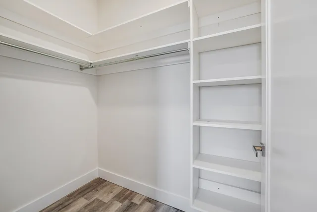 a view of walk in closet with empty racks