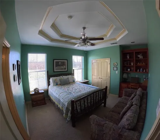 a bedroom with a bed dresser and a large window