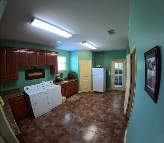 a room with furniture a flat screen tv and a refrigerator