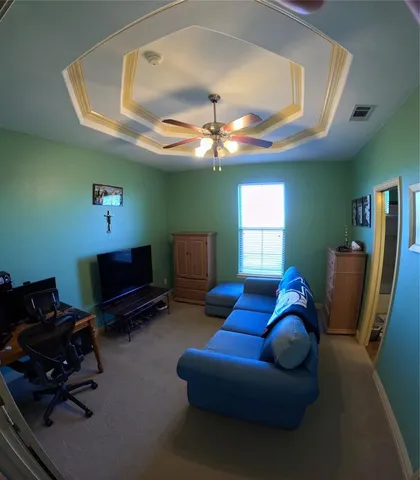 a living room with furniture a ceiling fan and a window