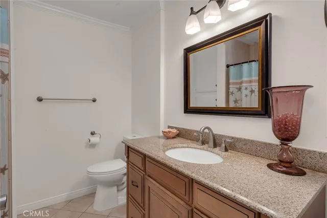 a bathroom with a granite countertop toilet sink and mirror