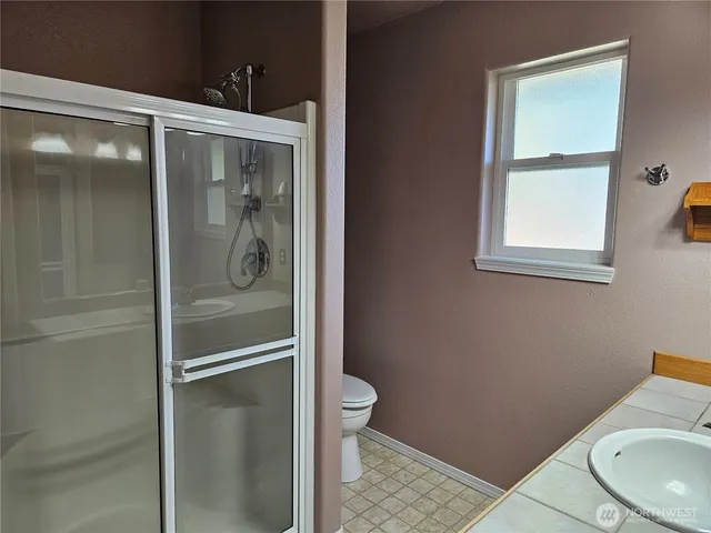 a bathroom with a granite countertop toilet and a sink