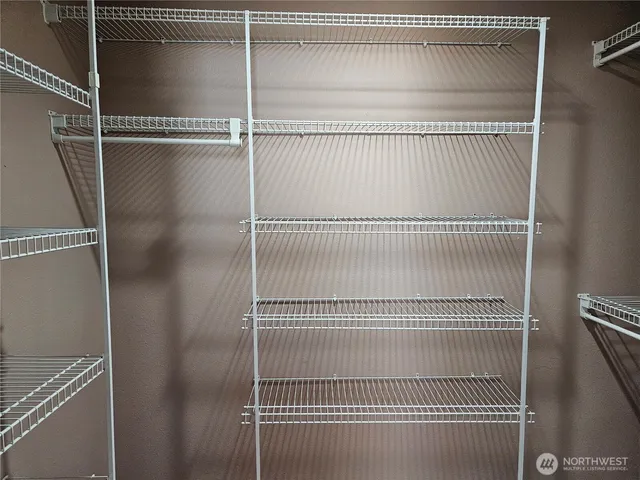 a small yard with large trees and wooden fence