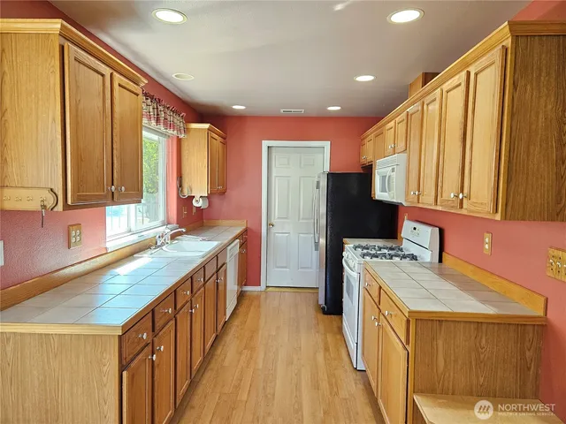 a kitchen with stainless steel appliances granite countertop a sink stove and cabinets