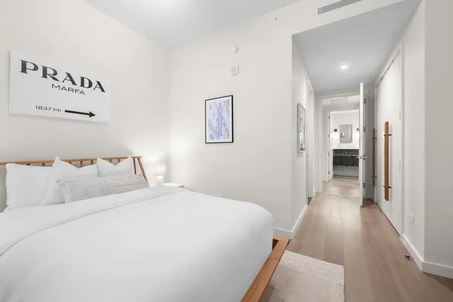 a bedroom with a bed and painting on the wall