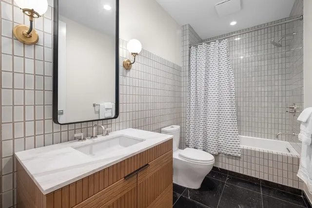a bathroom with a sink toilet vanity and shower