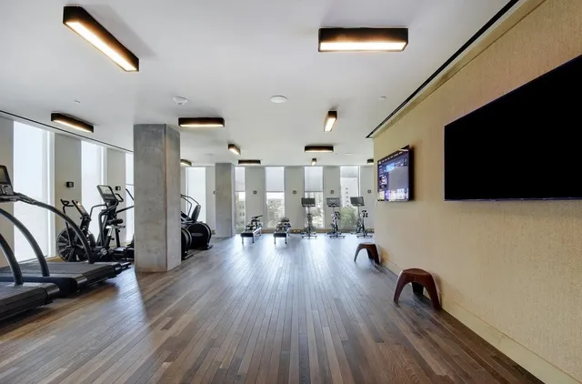 a view of a room with gym equipment and a flat screen tv